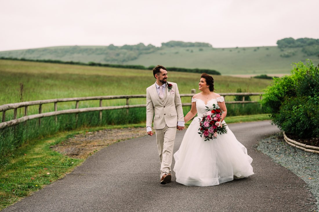 Natural couple photo of Bride and groom walking at their Long Furlong Barn wedding