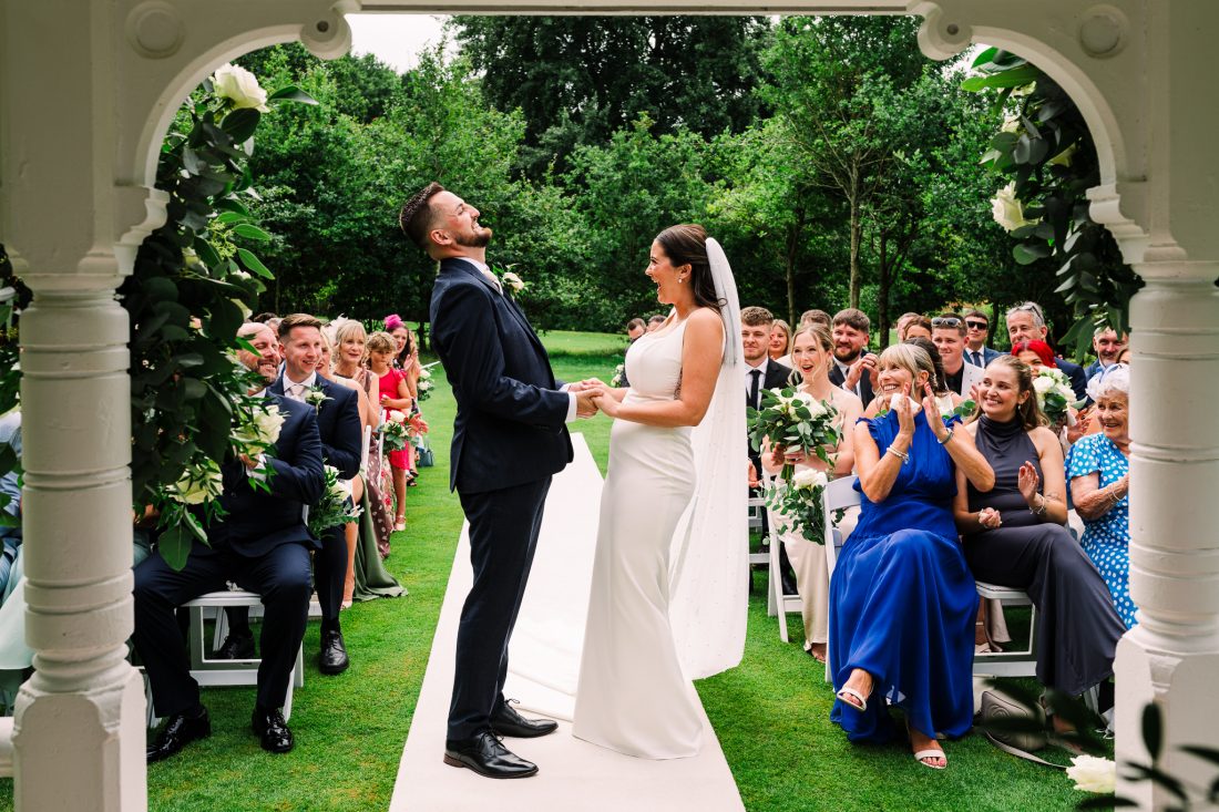 Bride and groom laughing during ceremony at The Cottesmore wedding