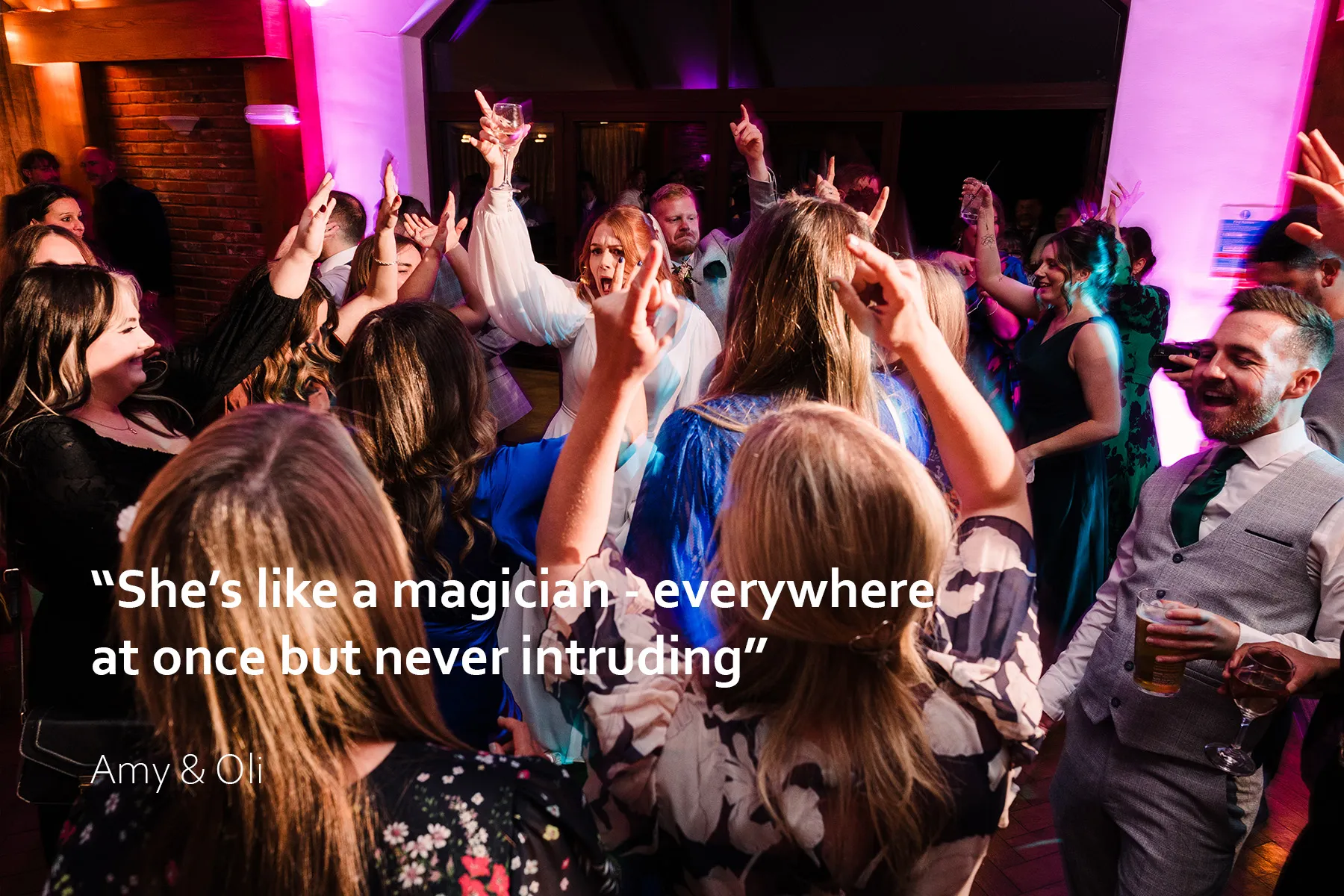 Bride with her hand in the air on a packed dancefloor at Westerham wedding