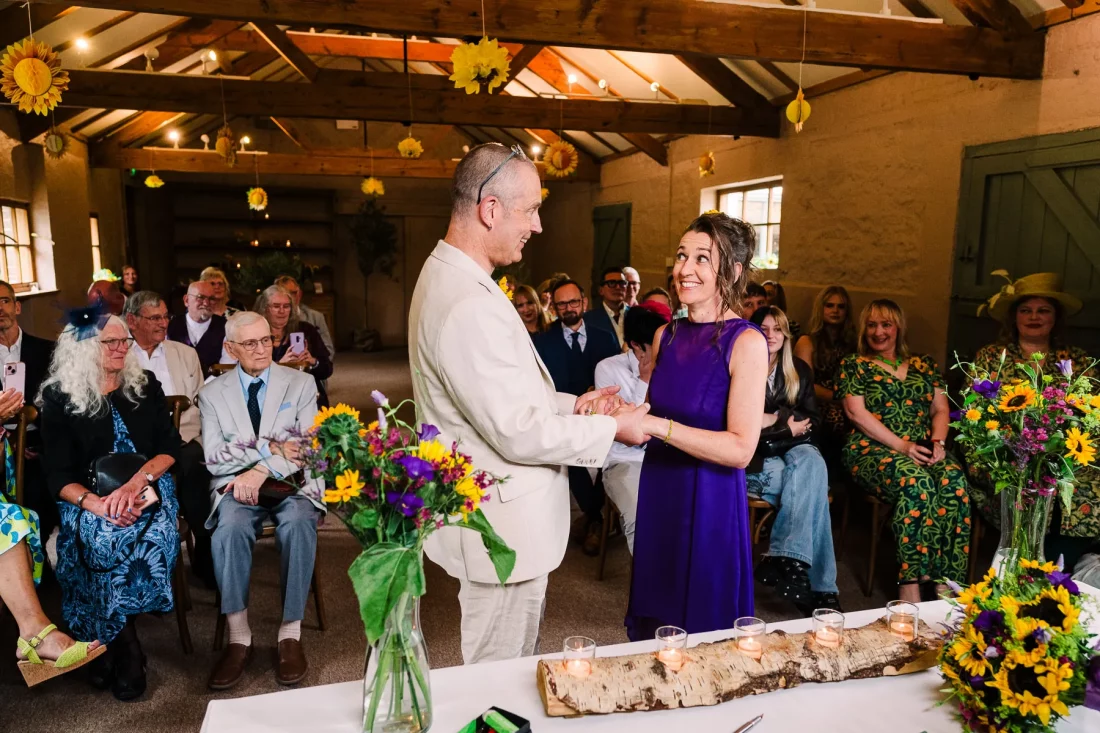 Fab expressions and purple wedding dress as bride and groom exchange vows during their wedding ceremony at Pangdean Barn