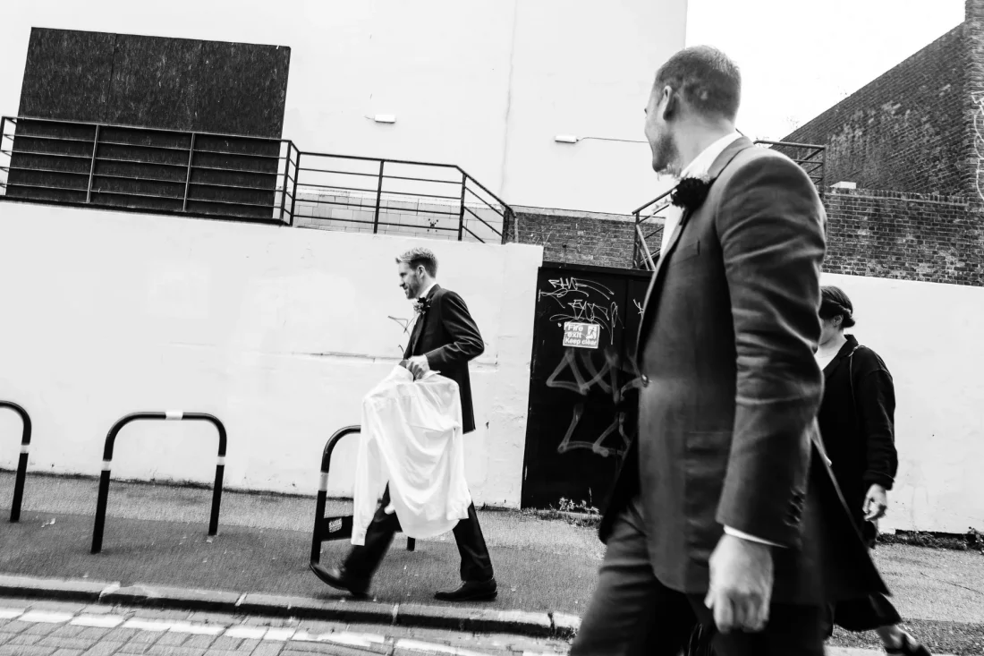 Black & White candid image of groom and groomsmen on way to Brighton wedding