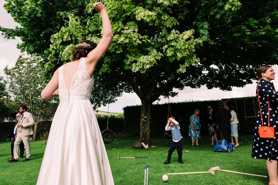 Boy with head in hands at bride beats him at croquet at Pangdean Old Barn wedding